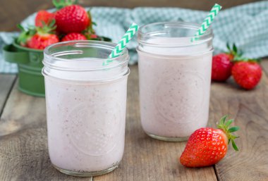 Healthy smoothie with strawberry, banana and yogurt in glass jar clipart