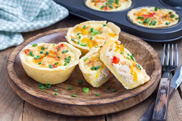 Mini quiche com frango e pimentão em uma placa de madeira — Fotografia de Stock