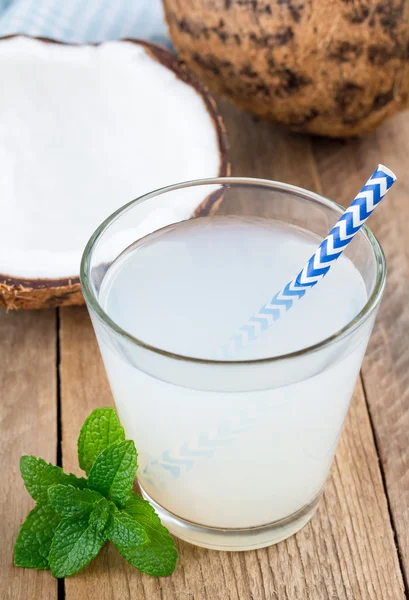 Kokosnoot drink met pulp in glas op houten tafel — Stockfoto