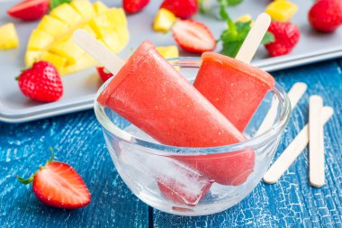 Ev yapımı çilekli-mango dondurmayı ahşap bir masa üzerinde