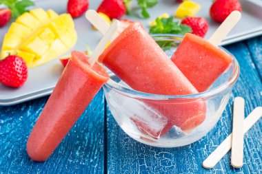 Ev yapımı çilekli-mango dondurmayı ahşap bir masa üzerinde