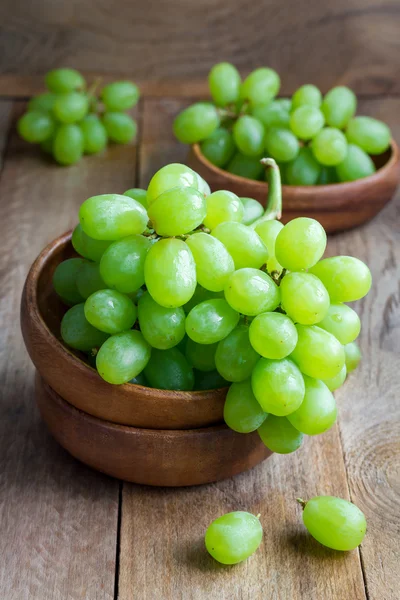 Bando de uvas verdes maduras em uma tigela de madeira — Fotografia de Stock