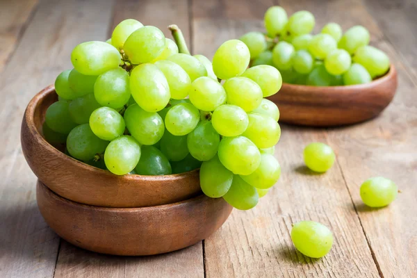 Bando de uvas verdes maduras em uma tigela de madeira — Fotografia de Stock