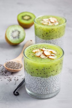 Vanilya chia puding tatlısı, beton arka plan kivi ile katmanlı