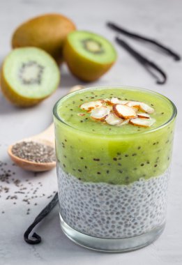 Vanilya chia puding tatlısı, beton arka plan kivi ile katmanlı