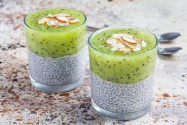 Vanilya chia puding tatlısı, beton arka plan kivi ile katmanlı