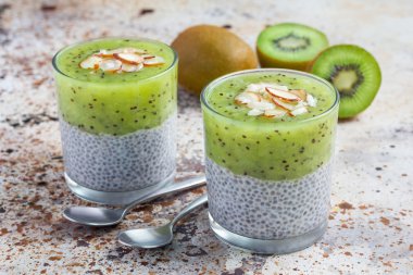 Vanilya chia puding tatlısı, beton arka plan kivi ile katmanlı