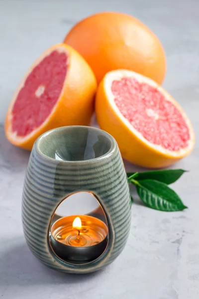 Aroma lampa s esenciální olej z grapefruitu, grapefruitů na pozadí — Stock fotografie