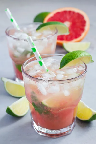 Cold pink cocktail with fresh grapefruit, lime and ice, vertical — Stock Photo, Image