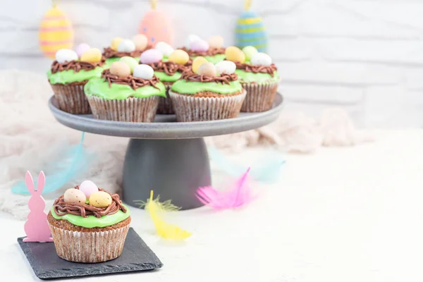 Osterkarottenmuffins Mit Frischkäse Zuckerguss Und Schokoladeneiern Auf Einem Grauen Kuchenständer — Stockfoto