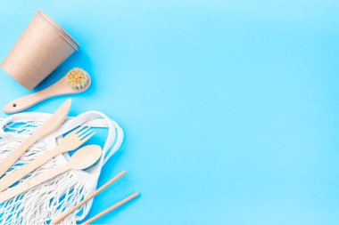 Sıfır atık veya plastiksiz konsept, ahşap ve kağıt kap, yeniden kullanılabilir çanta, mavi arkaplan, yatay, üst görünüm, kopyalama alanı