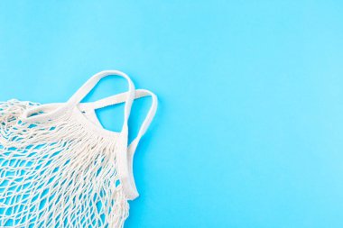 Mavi zemin üzerinde ağ torbası, sıfır atık veya plastik serbest konsept, yatay, üst görünüm, boşluk kopyala
