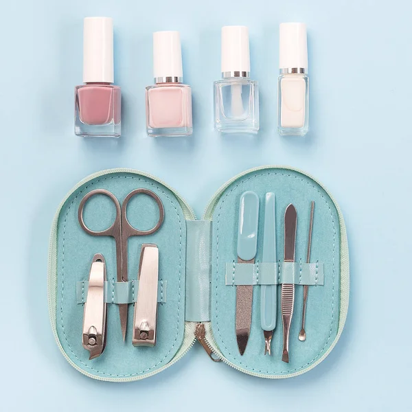 Spa set, manicure or pedicure equipment with nail coat or polish, on a blue background, top view, square format