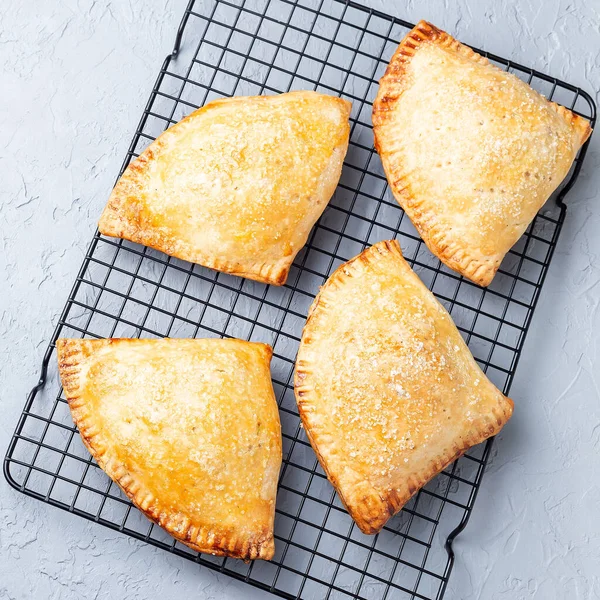 Küçük şeftali ve tarçınlı, hamur hamurlu, serinletici rafta şeker serpiştirilmiş, üst manzara, kare format