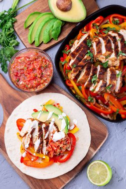 Biberli tavuk Fajitas, soğan, salsa Asada, avokado ve ekşi krema yumuşak tortilla, Güneybatı Tex-Mex Mutfağı, dikey, üst manzara