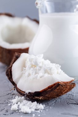 Hindistan cevizi, toz ve cam kavanozdaki suyla çözünmüş süt tozu, süt tozu, dikey.