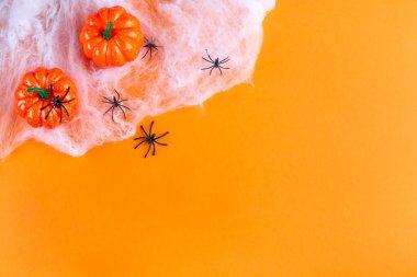 Ağlı Cadılar Bayramı arka planı, örümcekler ve balkabağı, turuncu kağıt üzerinde, yatay, üst görünüm, boşluğu kopyala