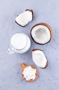 Hindistan cevizi, barut ve cam kavanozdaki suyla çözünmüş süt tozu, laktozsuz süt, dikey, üst görünüm.