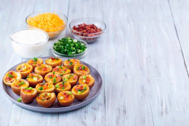 Fırınlanmış küçük kırmızı derili patates, kıtır pastırma, soğan ve keskin çedar peyniri, yatay, kopyalama alanı