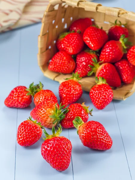 Panier avec des fraises renversant sur une table — Photo