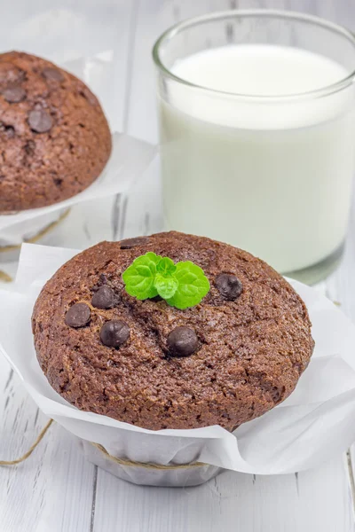 Leckere Schokoladenmuffins mit Schokochips und einem Glas Milch — Stockfoto
