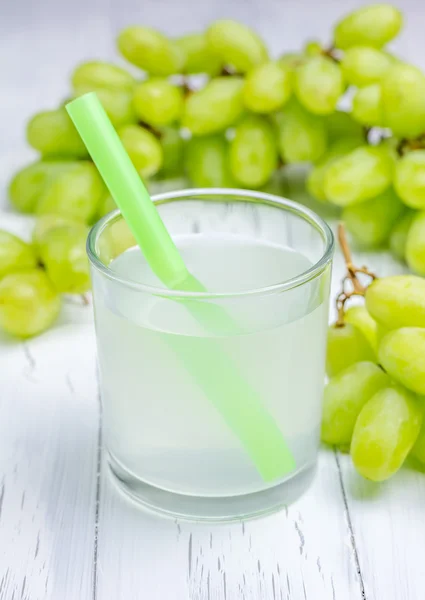 Copo de suco de uvas brancas e uvas no fundo — Fotografia de Stock