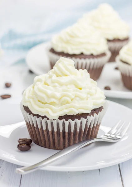 Schokoladen-Cupcakes mit Quark-Zuckerguss auf dem weißen Teller — Stockfoto
