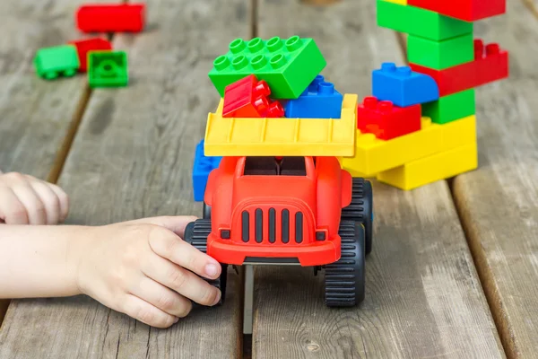 Gyermek játszó játék teherautó és műanyag építőelemek — Stock Fotó