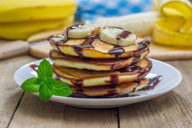 Yığın krep muz ve çikolata şurubu ile