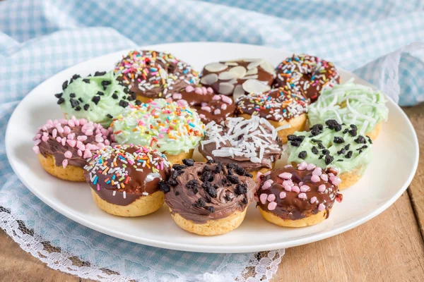 Mini donuts caseiros frescos assados em uma placa branca — Fotografia de Stock