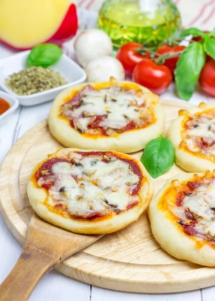 Міні піца з салямі, беконом, грибами та сиром — стокове фото