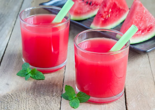 Un vaso de jugo de sandía fresca sobre una mesa de madera — Foto de Stock