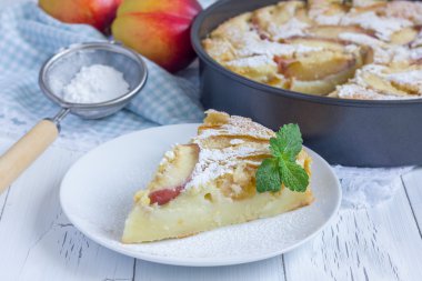 Slice of peach clafoutis on a white plate