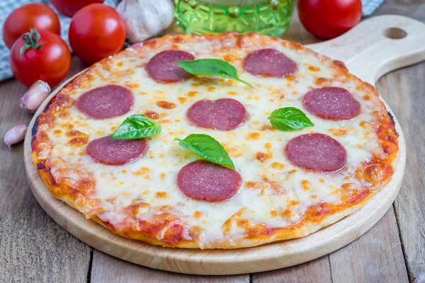 Hemgjord pepperoni pizza på en planka, redo att äta — Stockfoto