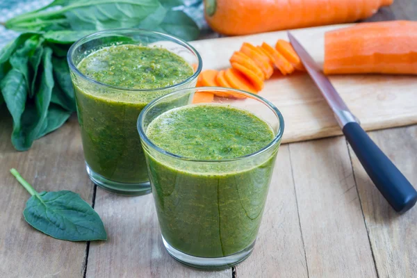 Здоровый зеленый коктейль из моркови со шпинатом в стакане — стоковое фото