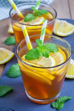 Refreshing homemade lemon iced tea on a black slate tray