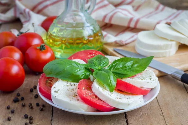 Салат из капрезе с помидорами, базиликом и моцареллой — стоковое фото
