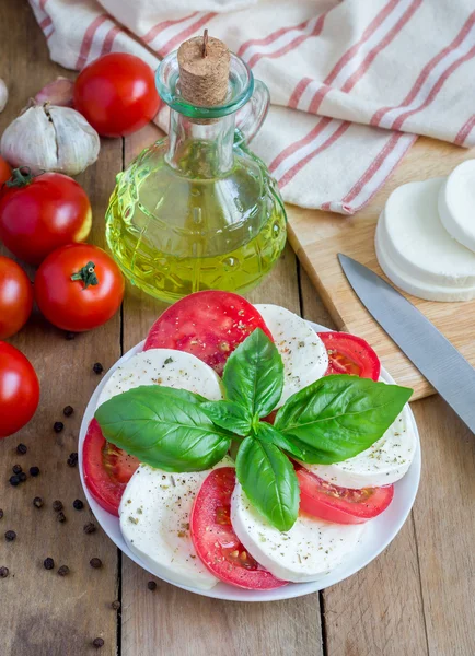 Салат из капрезе с помидорами, базиликом и моцареллой — стоковое фото