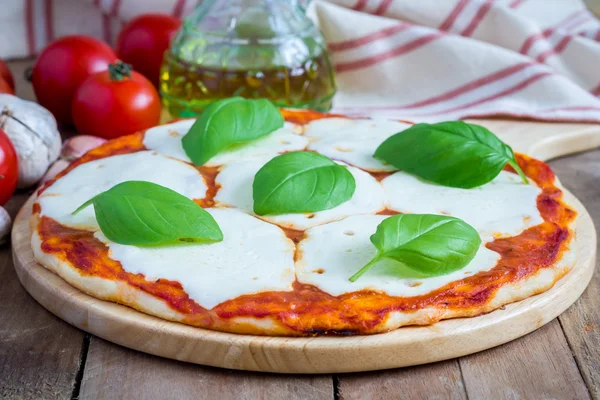 Margherita pizza caseira em uma placa de madeira — Fotografia de Stock