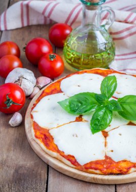 Homemade pizza with mozzarella cheese on a wooden board