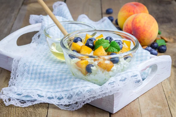 Queijo fresco com pêssego, mirtilo, amêndoas e mel. Conceito de alimentação saudável para o café da manhã . — Fotografia de Stock