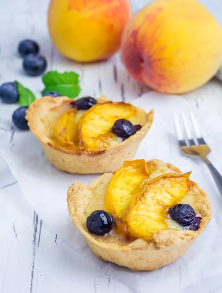 Homemade tartlets with peach and blueberries — Stock Photo, Image