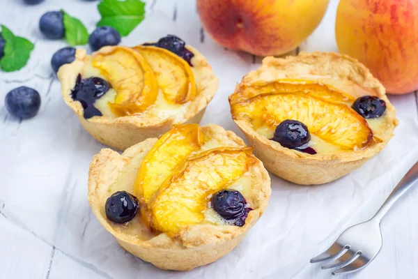 Homemade tartlets with peach and blueberries — Stock Photo, Image