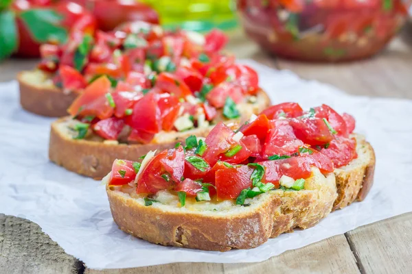 Bruschetta z pomidorami, ziołami i oleju na Pieczywo czosnkowe tosty ser — Zdjęcie stockowe