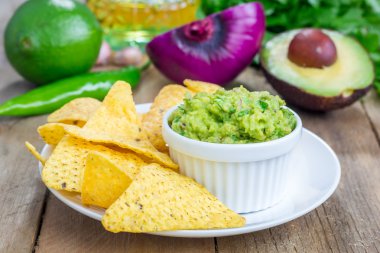 Tıknaz guacamole cips ve malzemelerin üzerine backgroung ile servis fincanla