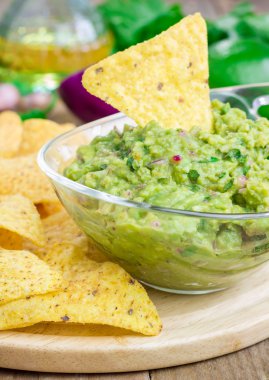 Tıknaz guacamole cips ve malzemelerin üzerine backgroung ile servis ile kase
