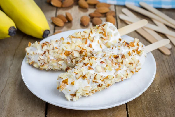 Frozen banana covered with yogurt and almonds