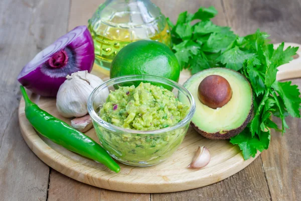 Skål med chunky guacamole och ingredienser — Stockfoto