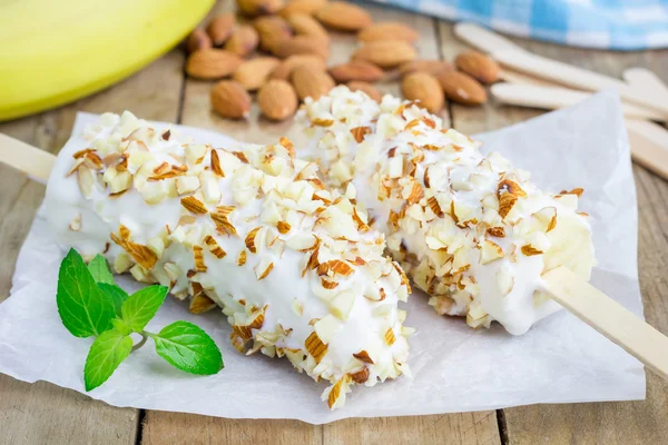 Banana congelada coberta de iogurte e amêndoas — Fotografia de Stock