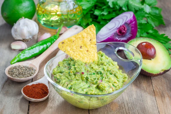 Skål med chunky guacamole och ingredienser — Stockfoto